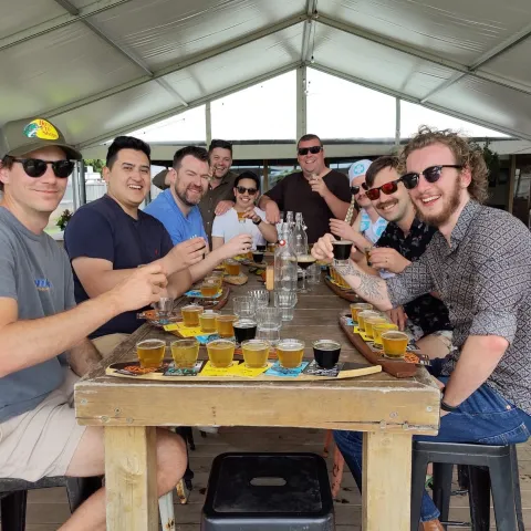 a group of people standing on top of a wooden table