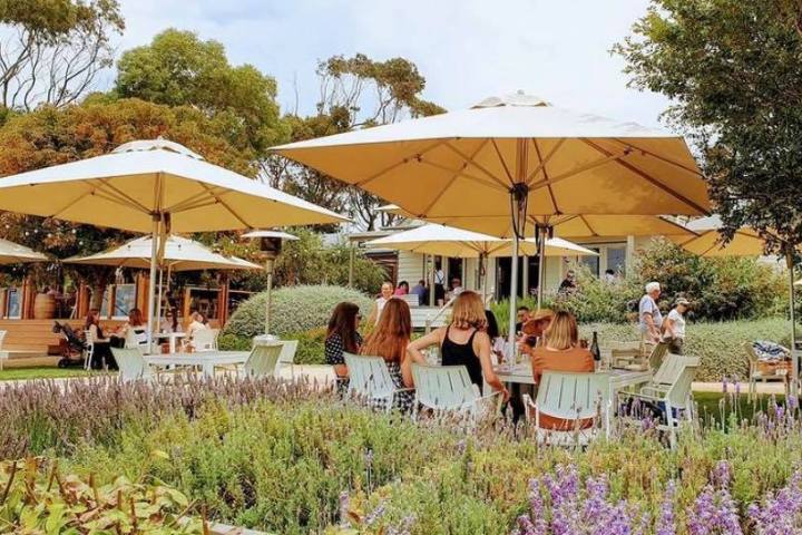 a group of people sitting at a table with an umbrella