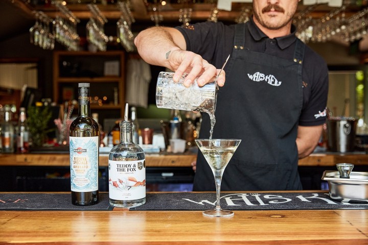 a man holding a glass of wine on a table
