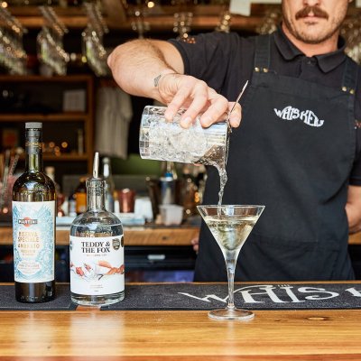 a man holding a glass of wine on a table