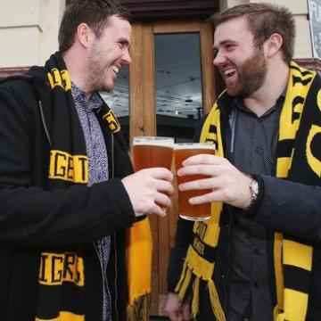 a man wearing a suit and tie holding his hand up